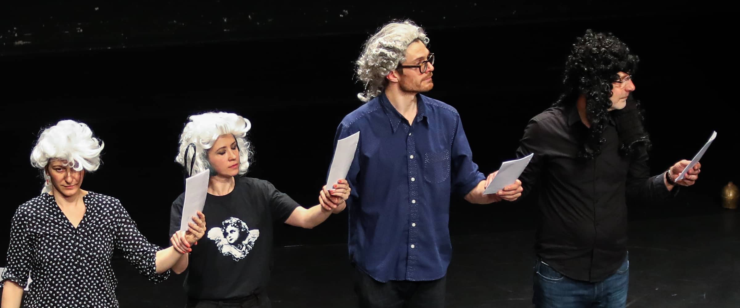 Performers wearing wigs dance with scores in their hands